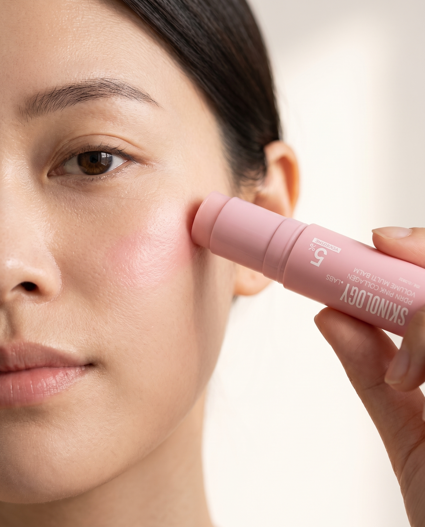 Skinology.Labs PDRN Pink Collagen Volume Multi Balm being glided across a cheekbone